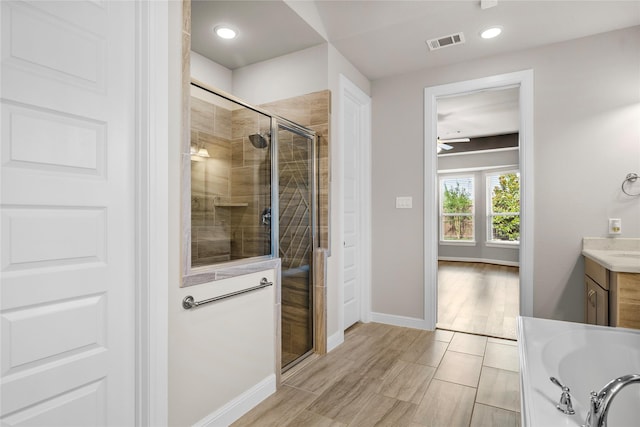5715 Caper Shores Ln, Sugar Land, TX 77479 - full bath with vanity, a shower stall, a ceiling fan, a tub, and recessed lighting