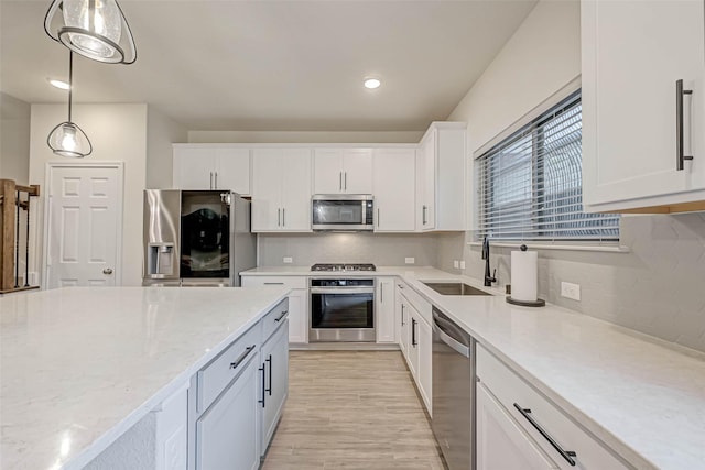 3226 Longleaf Meadows Dr, Houston, TX 77063 - kitchen featuring stainless steel appliances, white cabinetry, tasteful backsplash, light wood-type flooring, and hanging light fixtures