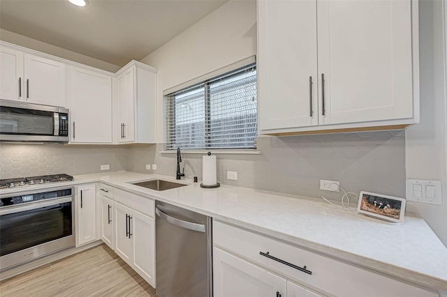 3226 Longleaf Meadows Dr, Houston, TX 77063 - kitchen with stainless steel appliances, decorative backsplash, light countertops, white cabinetry, and light wood-style floors