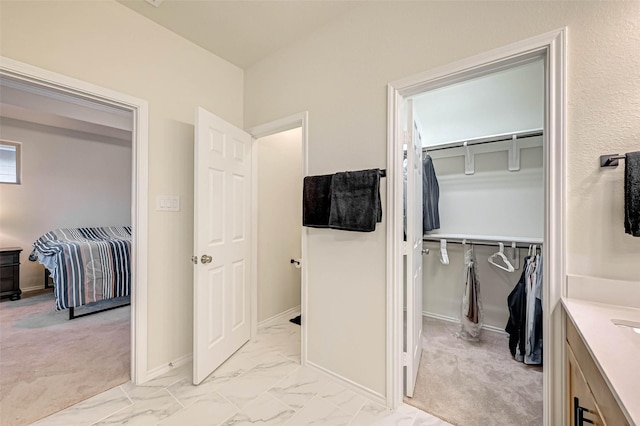 3226 Longleaf Meadows Dr, Houston, TX 77063 - bathroom featuring marble look tiles, vanity, and a spacious closet