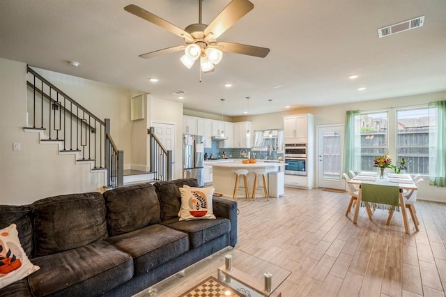 3226 Longleaf Meadows Dr, Houston, TX 77063 - living area with light wood-style floors, ceiling fan, stairs, and recessed lighting