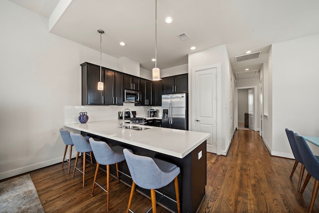 3929 Tulane Oak Dr, Houston, TX 77018 - kitchen featuring appliances with stainless steel finishes, a breakfast bar, dark wood-type flooring, light countertops, and a peninsula