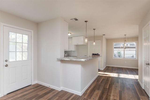 12707 Pleasant Grove Rd, Cypress, TX 77429 - kitchen with a chandelier, white cabinets, dark wood finished floors, light stone countertops, and pendant lighting