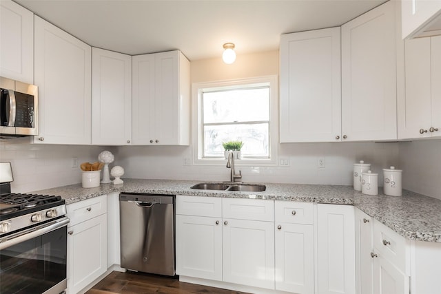 12707 Pleasant Grove Rd, Cypress, TX 77429 - kitchen with appliances with stainless steel finishes, decorative backsplash, white cabinetry, dark wood-type flooring, and light stone countertops