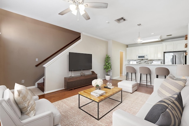 1708 Dennis St, Houston, TX 77004 - living area with stairway, a ceiling fan, light wood finished floors, recessed lighting, and ornamental molding
