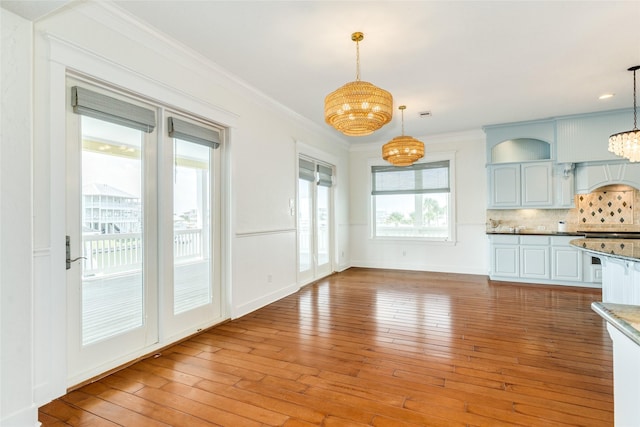 20611 E Sunset Bay Dr, Galveston, TX 77554 - unfurnished dining area with a chandelier, light wood finished floors, and ornamental molding