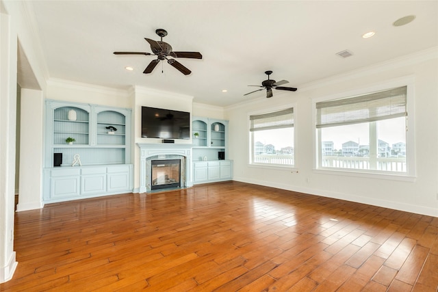 20611 E Sunset Bay Dr, Galveston, TX 77554 - unfurnished living room with plenty of natural light, ceiling fan, crown molding, wood finished floors, and a high end fireplace