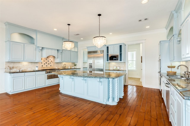 20611 E Sunset Bay Dr, Galveston, TX 77554 - kitchen featuring built in appliances, a chandelier, a center island, open shelves, and a breakfast bar area