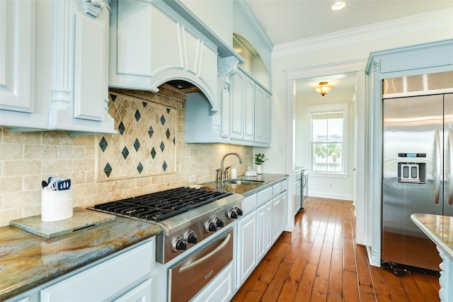 20611 E Sunset Bay Dr, Galveston, TX 77554 - kitchen featuring appliances with stainless steel finishes, a warming drawer, light stone countertops, crown molding, and white cabinetry
