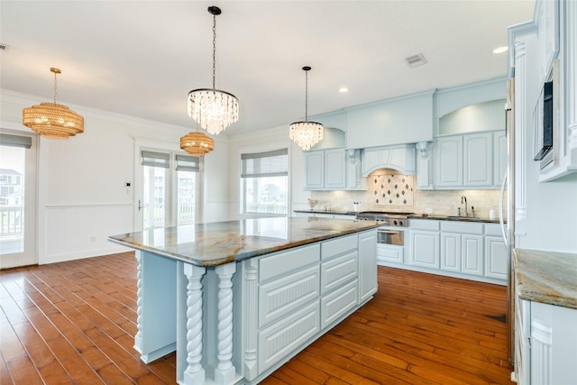 20611 E Sunset Bay Dr, Galveston, TX 77554 - kitchen featuring premium range hood, a kitchen island, crown molding, a chandelier, and backsplash