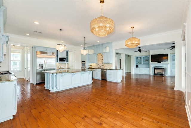 20611 E Sunset Bay Dr, Galveston, TX 77554 - kitchen featuring appliances with stainless steel finishes, a ceiling fan, crown molding, open floor plan, and a chandelier