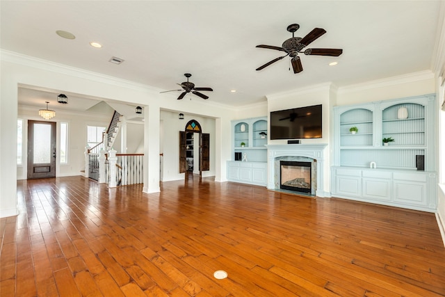 20611 E Sunset Bay Dr, Galveston, TX 77554 - unfurnished living room with crown molding, a fireplace, hardwood / wood-style floors, stairway, and ceiling fan