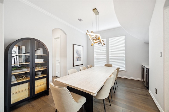 1120 Wakefield Dr, Houston, TX 77018 - dining room featuring a chandelier, ornamental molding, arched walkways, and dark wood-type flooring