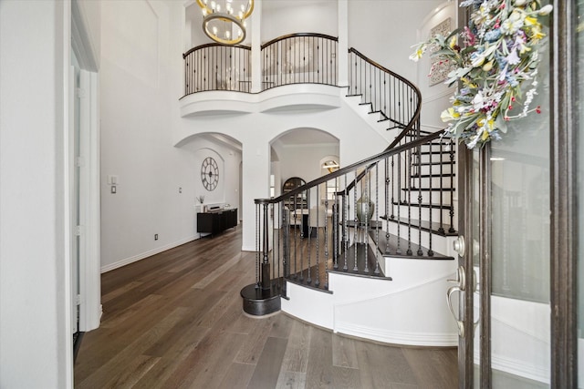 1120 Wakefield Dr, Houston, TX 77018 - foyer entrance featuring a towering ceiling, arched walkways, wood finished floors, stairway, and a chandelier