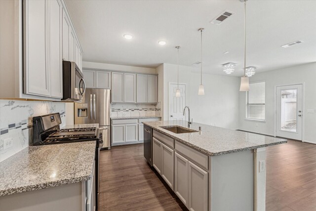 10967 Cannes Memorial Dr, Houston, TX 77043 - kitchen featuring appliances with stainless steel finishes, dark wood finished floors, decorative backsplash, light stone counters, and recessed lighting