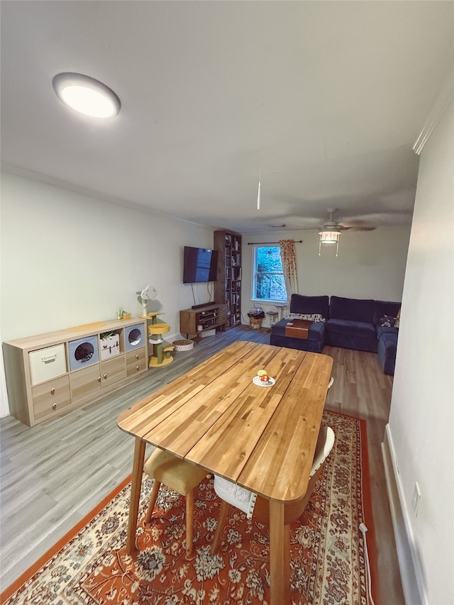 5205 Kashmere St, Houston, TX 77026 - dining room with wood finished floors, ceiling fan, and a wood stove