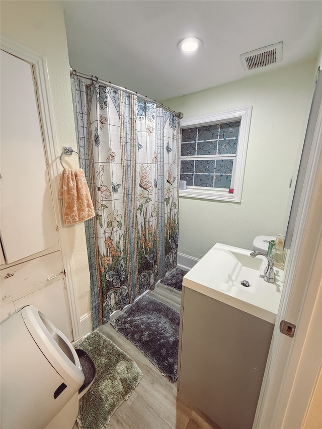 5205 Kashmere St, Houston, TX 77026 - bathroom with vanity, curtained shower, and wood finished floors