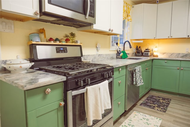 5205 Kashmere St, Houston, TX 77026 - kitchen featuring stainless steel appliances, white cabinets, green cabinets, and light wood finished floors