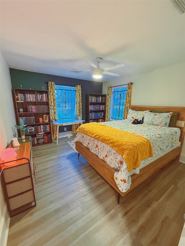 5205 Kashmere St, Houston, TX 77026 - bedroom featuring wood finished floors, multiple windows, and a ceiling fan