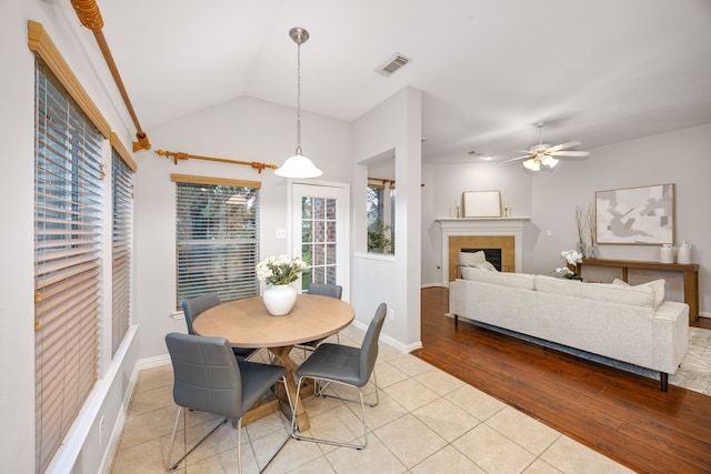 18419 S Raven Shore Dr, Cypress, TX 77433 - dining area with plenty of natural light, a glass covered fireplace, a ceiling fan, light tile patterned floors, and lofted ceiling