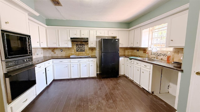 9518 Langdon Ln, Houston, TX 77036 - kitchen featuring black appliances, white cabinets, dark wood finished floors, dark countertops, and decorative backsplash