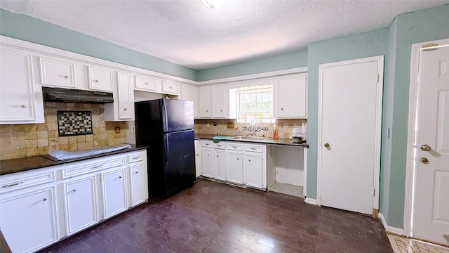 9518 Langdon Ln, Houston, TX 77036 - kitchen featuring freestanding refrigerator, under cabinet range hood, cooktop, dark countertops, and a textured ceiling