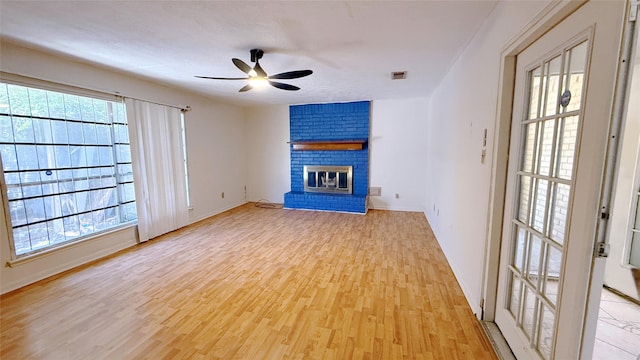 9518 Langdon Ln, Houston, TX 77036 - unfurnished living room with light wood-style flooring, ceiling fan, plenty of natural light, and a fireplace