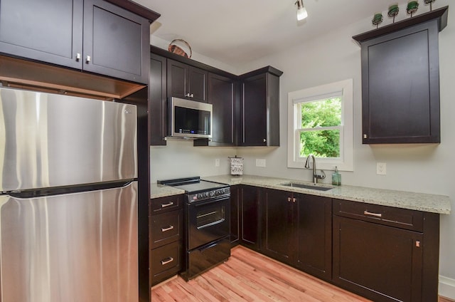 626 E 22nd St, Houston, TX 77008 - kitchen with appliances with stainless steel finishes, light wood-style floors, light stone countertops, and dark brown cabinetry