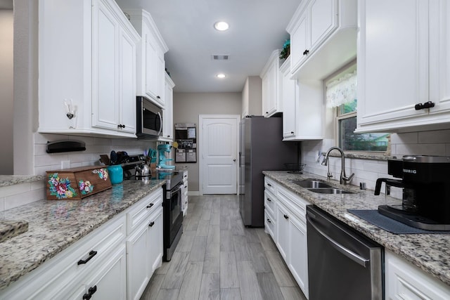 5 Corkwood Rd, Trinity, TX 75862 - kitchen featuring stainless steel appliances, white cabinets, tasteful backsplash, recessed lighting, and light stone countertops