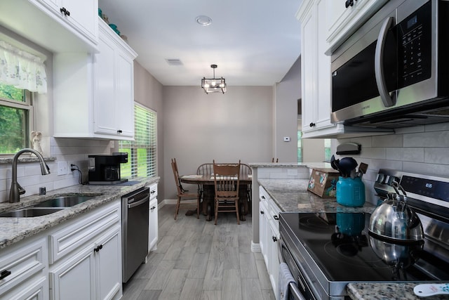 5 Corkwood Rd, Trinity, TX 75862 - kitchen featuring stainless steel appliances, decorative backsplash, white cabinetry, light stone countertops, and light wood finished floors