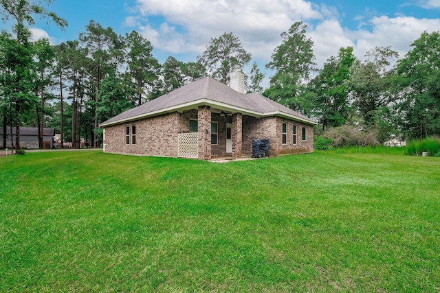 5 Corkwood Rd, Trinity, TX 75862 - back of property with brick siding, a yard, and a chimney