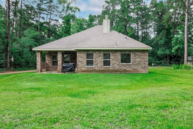 5 Corkwood Rd, Trinity, TX 75862 - back of property featuring a chimney, a lawn, brick siding, and a shingled roof