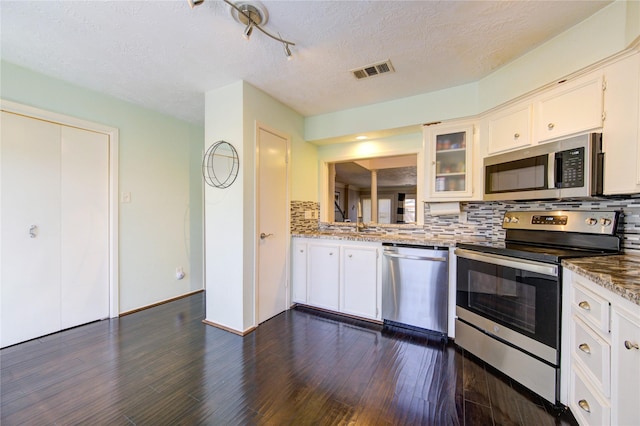 5830 Sampley Way Unit 5830, Houston, TX 77092 - kitchen featuring stainless steel appliances, decorative backsplash, dark wood-style floors, white cabinetry, and a textured ceiling