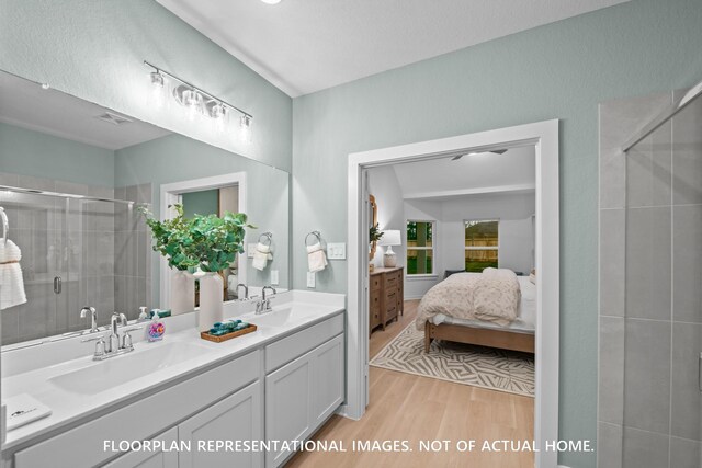 20530 Draper Rd, Tomball, TX 77377 - ensuite bathroom with double vanity, a shower stall, and wood finished floors