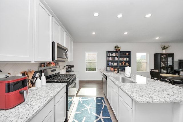 23238 Spring Genesis Ln, Katy, TX 77493 - kitchen with stainless steel appliances, recessed lighting, white cabinetry, tasteful backsplash, and wood finished floors