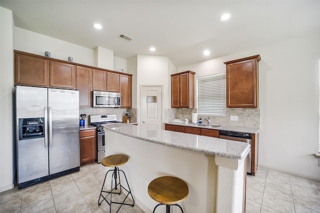 2614 Maverick Park Ln, Katy, TX 77449 - kitchen featuring stainless steel appliances, a kitchen island, tasteful backsplash, a breakfast bar area, and recessed lighting