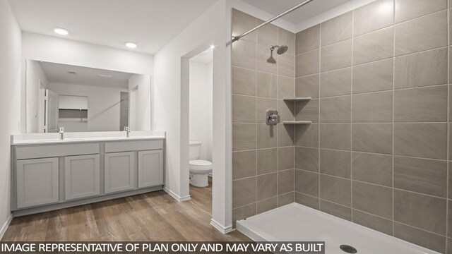 546 Belle Springs Ln, Conroe, TX 77301 - full bathroom with wood finished floors, double vanity, a tile shower, and recessed lighting