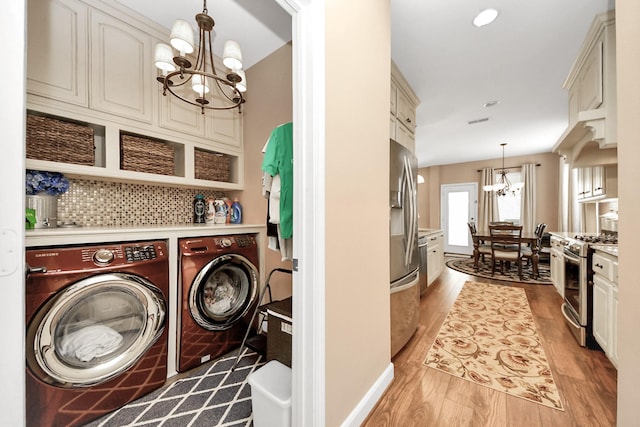 6111 Meadowstream Ct, Katy, TX 77450 - laundry room featuring a chandelier, independent washer and dryer, and light wood-style flooring