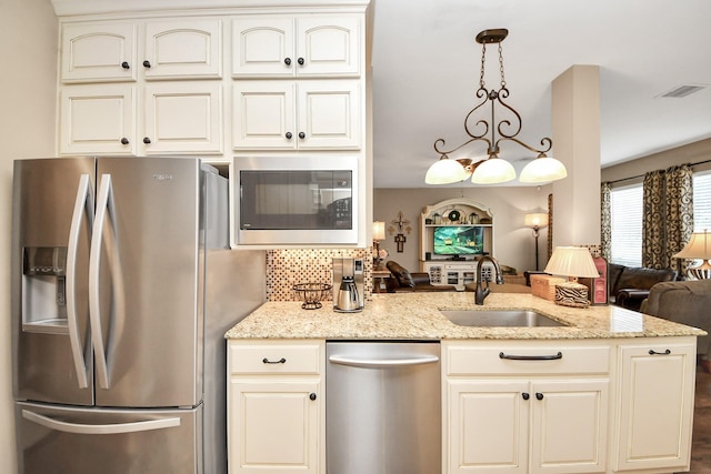6111 Meadowstream Ct, Katy, TX 77450 - kitchen with stainless steel appliances, open floor plan, light stone countertops, decorative backsplash, and a peninsula