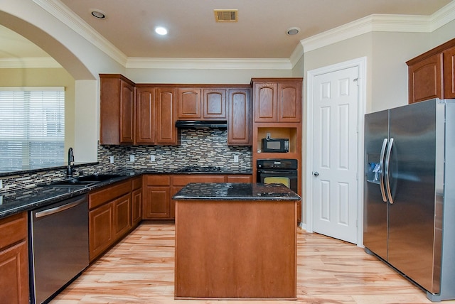 14431 Basalt Ln, Houston, TX 77077 - kitchen featuring black appliances, a kitchen island, light wood-style floors, arched walkways, and crown molding