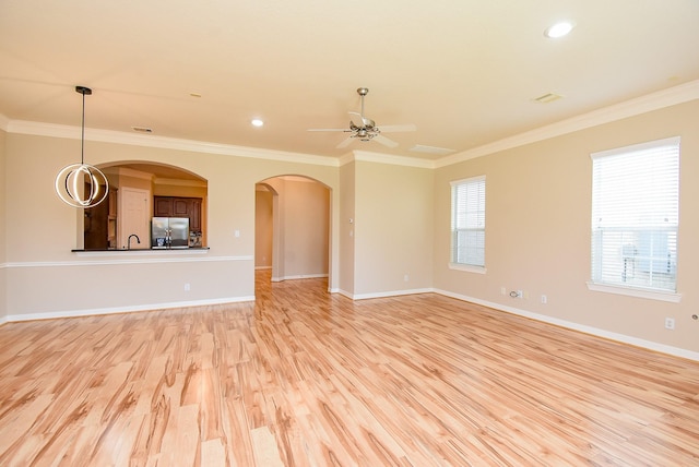 14431 Basalt Ln, Houston, TX 77077 - unfurnished living room featuring light wood-style floors, crown molding, ceiling fan, arched walkways, and recessed lighting