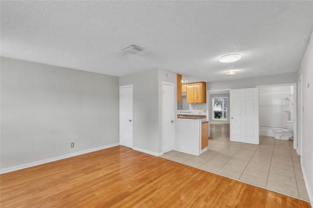 11515 Duane St, Houston, TX 77047 - kitchen featuring light wood-style flooring, a textured ceiling, and open floor plan