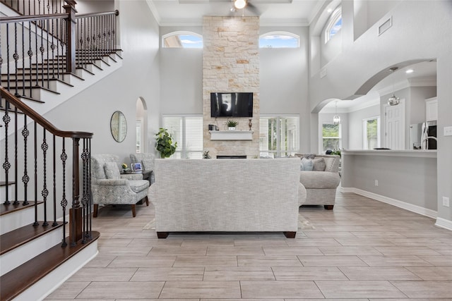 4511 Palo Pinto Dr, Houston, TX 77041 - living area with stairs, a stone fireplace, a towering ceiling, arched walkways, and ornamental molding