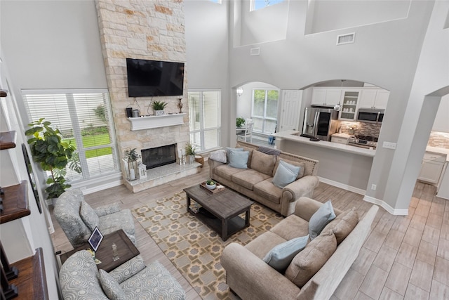 4511 Palo Pinto Dr, Houston, TX 77041 - living room featuring a fireplace, light wood finished floors, plenty of natural light, and a high ceiling