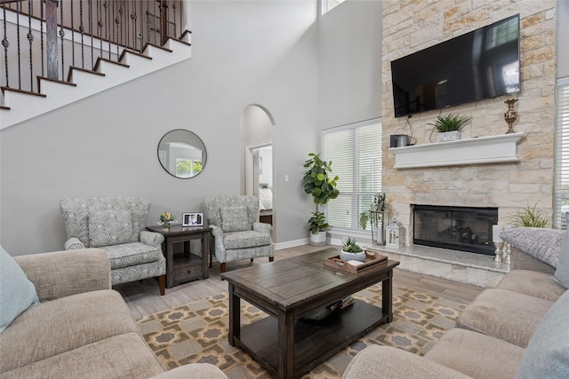 4511 Palo Pinto Dr, Houston, TX 77041 - living room with wood finished floors, a towering ceiling, a fireplace, healthy amount of natural light, and arched walkways