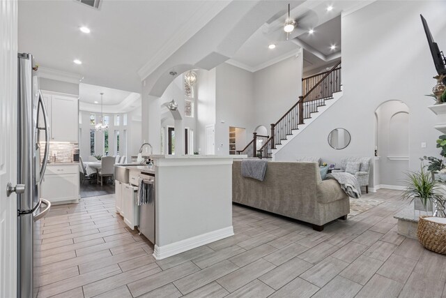 4511 Palo Pinto Dr, Houston, TX 77041 - kitchen with open floor plan, arched walkways, ornamental molding, light countertops, and white cabinetry