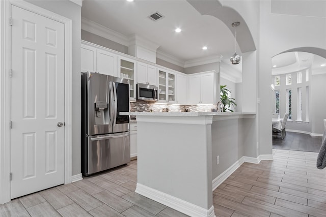 4511 Palo Pinto Dr, Houston, TX 77041 - kitchen featuring stainless steel appliances, arched walkways, wood finish floors, light countertops, and tasteful backsplash