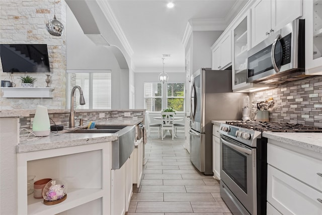 4511 Palo Pinto Dr, Houston, TX 77041 - kitchen featuring appliances with stainless steel finishes, ornamental molding, tasteful backsplash, white cabinets, and light stone countertops