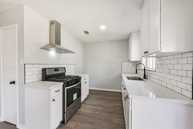1310 Beaver Bend Rd, Houston, TX 77088 - kitchen featuring exhaust hood, stainless steel gas range oven, backsplash, light countertops, and dark wood-type flooring