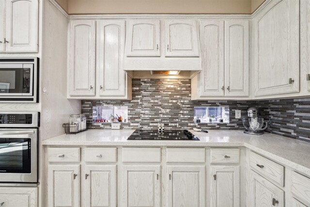 3919 Park Circle Way, Houston, TX 77059 - kitchen with stainless steel appliances, backsplash, and white cabinetry